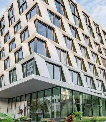 Moderne Bürogebäude-Architektur des Projekts ONE PLAZA mit markanter Fassade und großen Glasflächen